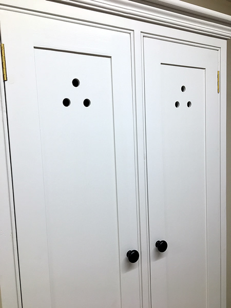 freestanding larder cupboard with fretwork cutouts in the door panels